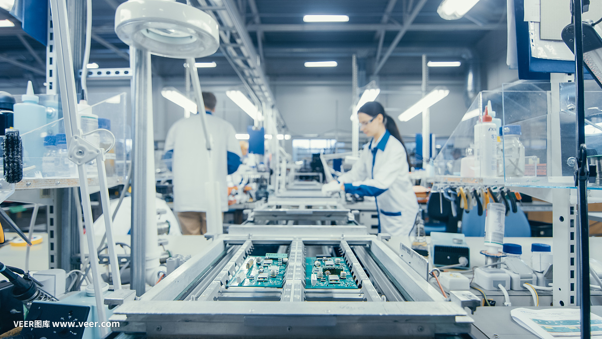 圖為電子廠工人在裝配線上手工組裝電路板。高科技工廠設(shè)施。